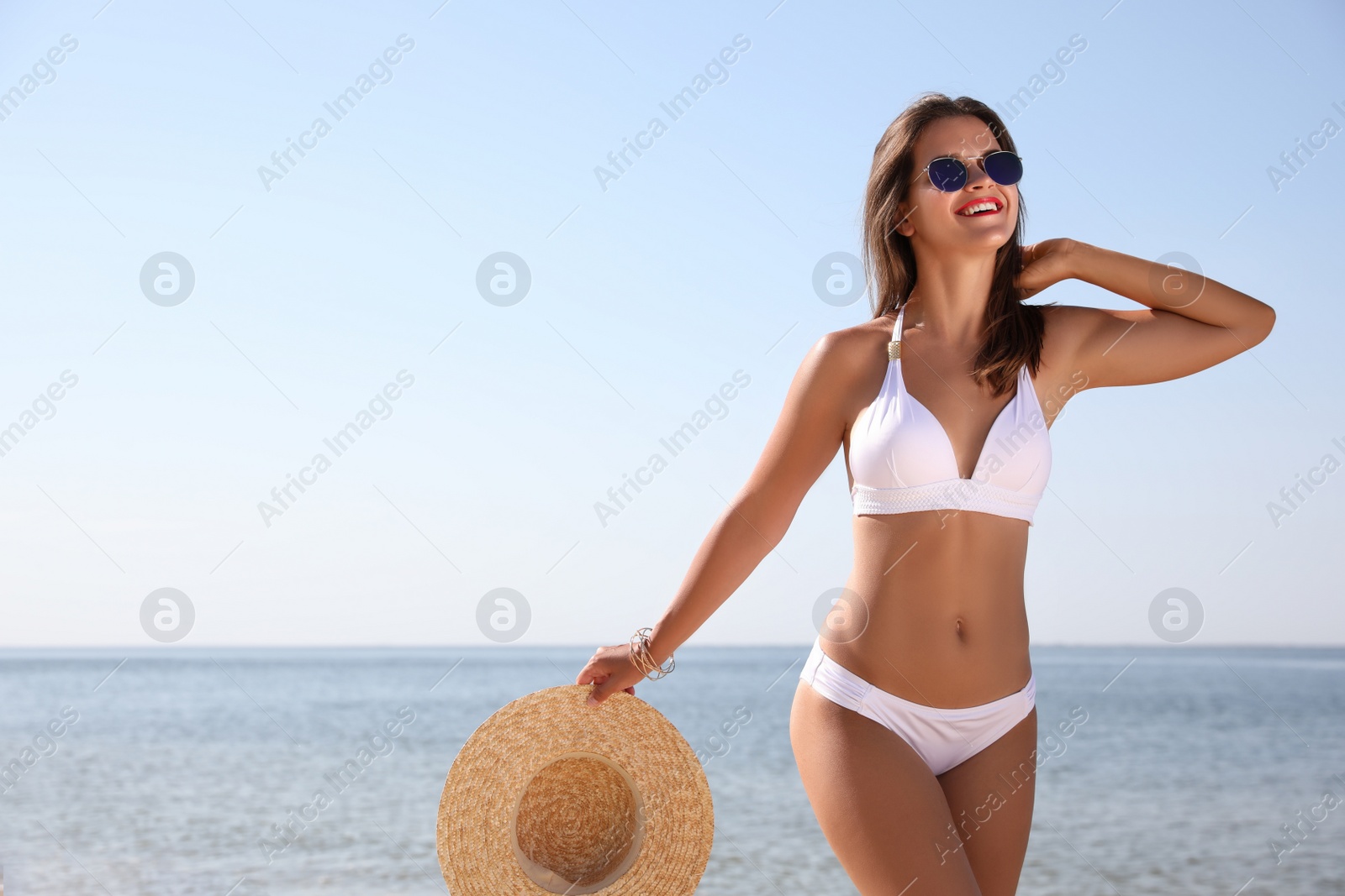 Photo of Young woman with beautiful body on beach. Space for text