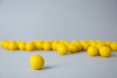 Photo of Delicious lemon chewing gums on light grey background, closeup