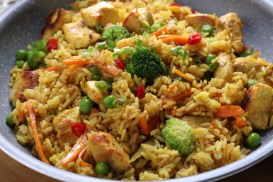 Photo of Tasty rice with meat and vegetables in frying pan, closeup