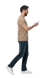 Photo of Handsome man with smartphone walking on white background