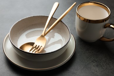Photo of Stylish empty dishware and cutlery on grey table, closeup