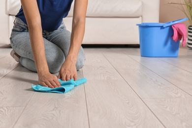 Young woman washing floor with rag, closeup with space for text. Cleaning service