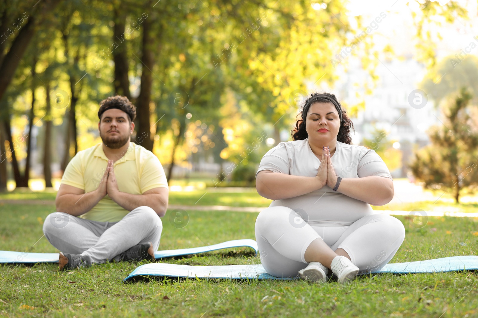 Photo of Overweight couple training together in park on sunny day