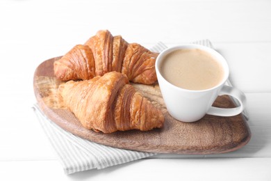 Photo of Tasty breakfast. Cup of coffee and croissants on white wooden table