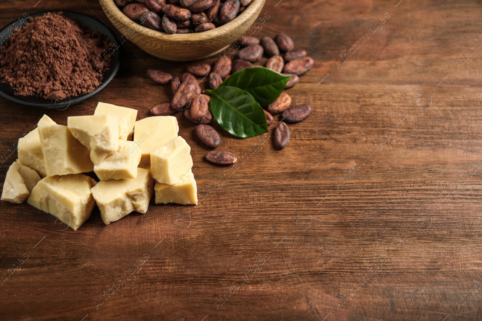 Photo of Composition with organic cocoa butter on wooden table. Space for text