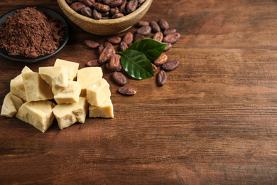 Composition with organic cocoa butter on wooden table. Space for text