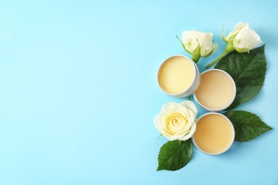 Hygienic lip balms and flowers on color background