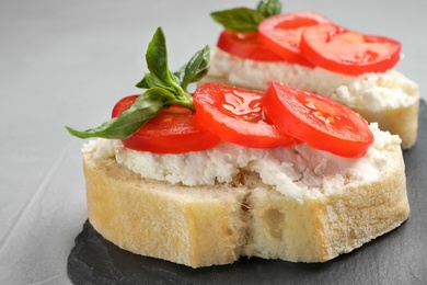 Tasty fresh tomato bruschettas on grey table, closeup