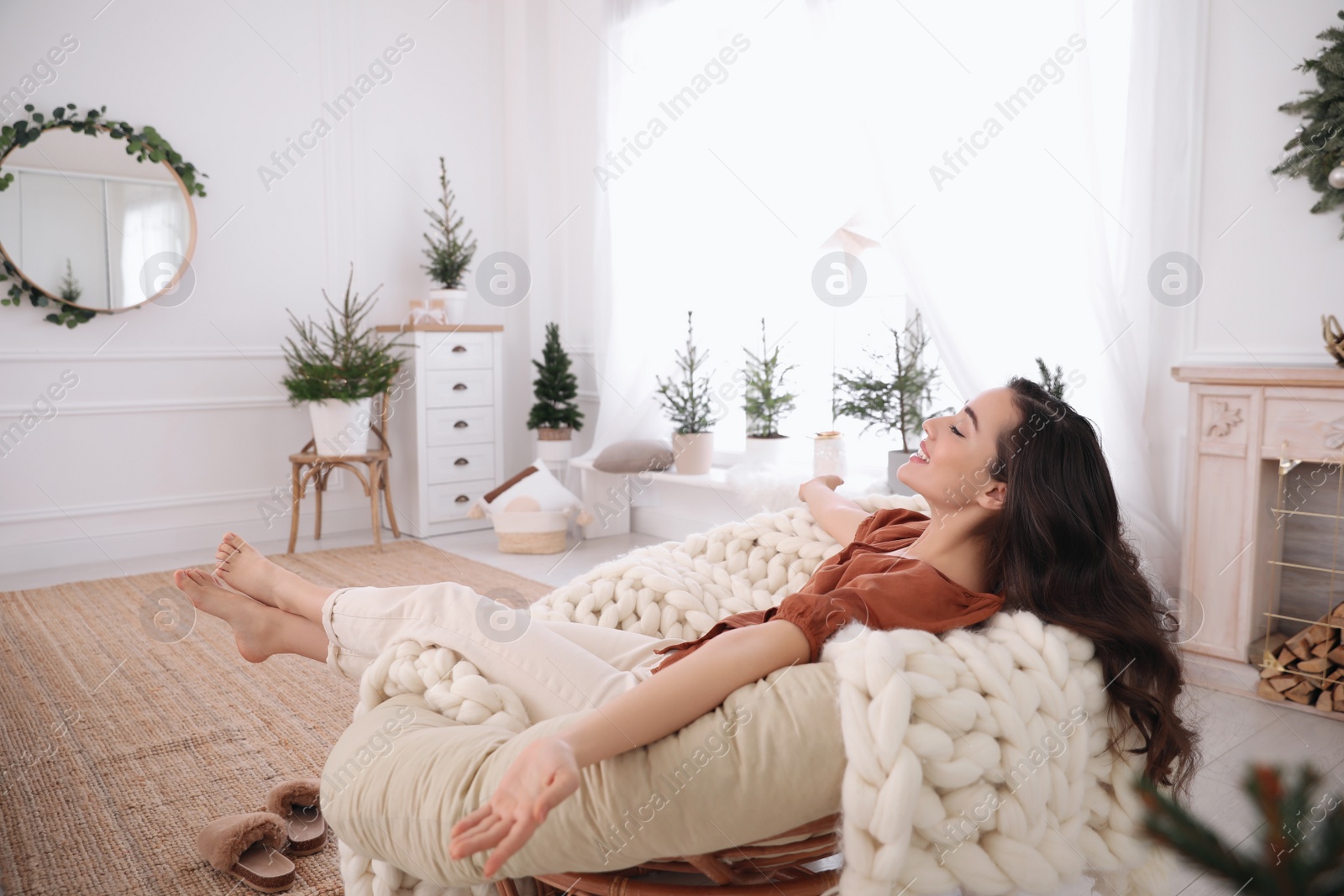 Photo of Woman resting in comfortable papasan chair at home
