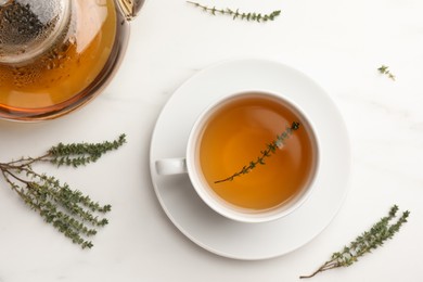 Aromatic herbal tea with thyme on white table, flat lay