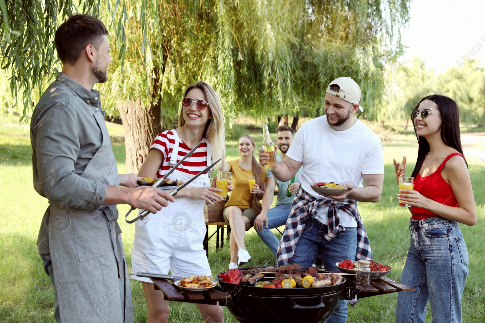 Photo of Group of friends having barbecue party in park