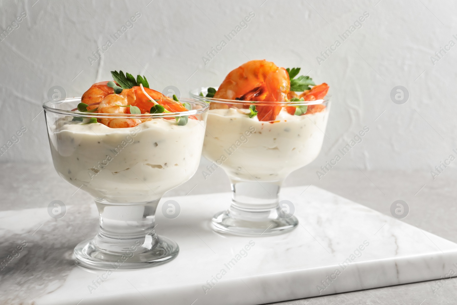 Photo of Bowls with fried shrimps and sauce on marble board