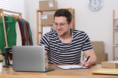 Photo of Seller with laptop working in office. Online store