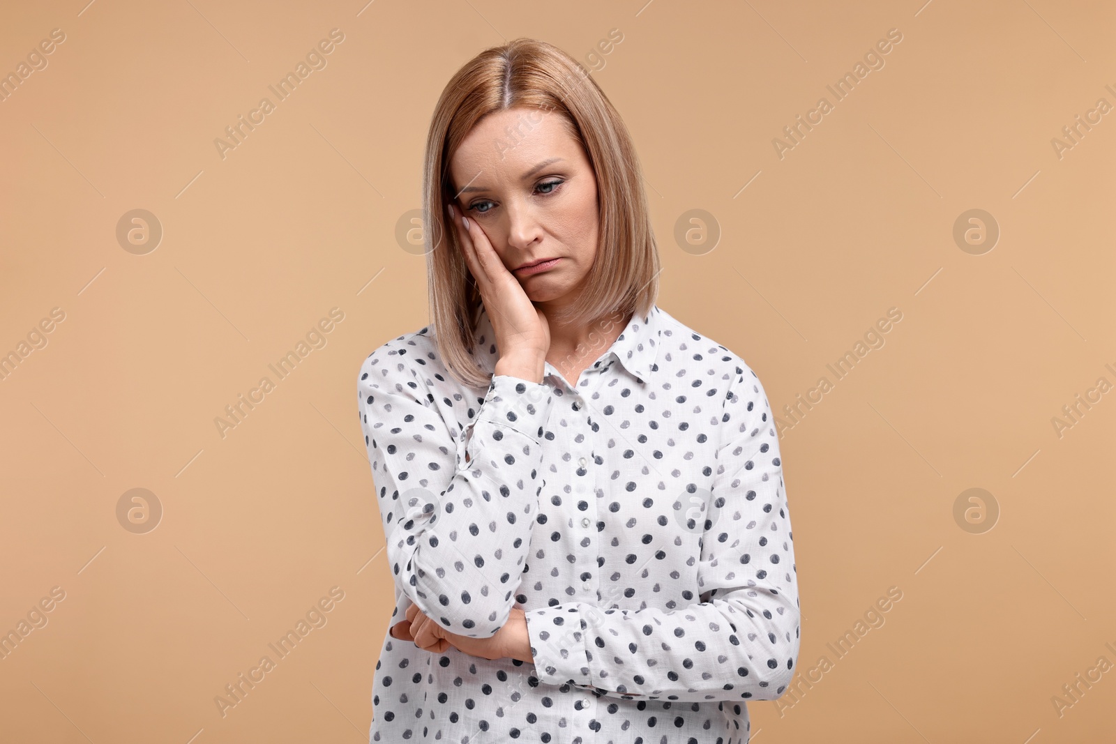 Photo of Portrait of sad woman on beige background