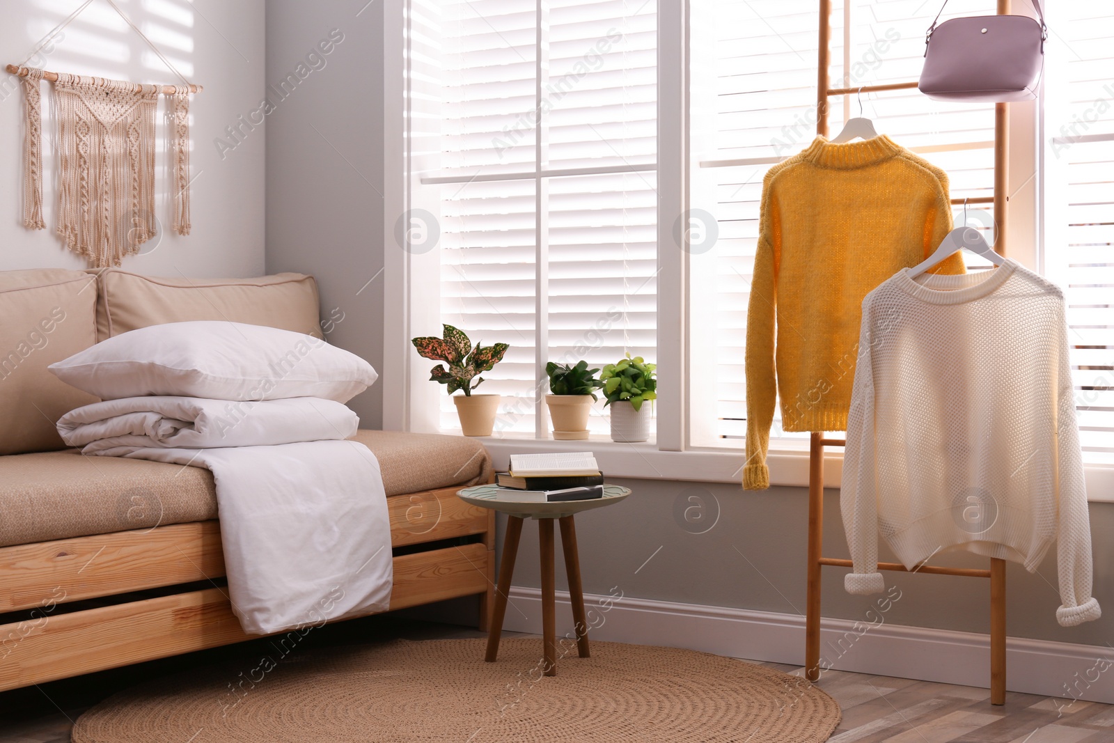 Photo of Comfortable sofa with blanket near window indoors