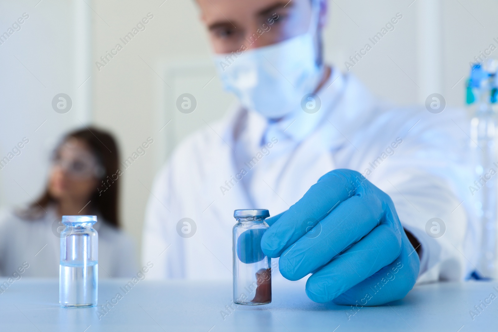 Photo of Scientist taking medical ampoule indoors, focus on hand. Laboratory analysis