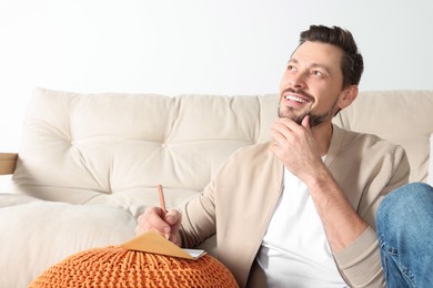 Man writing message in greeting card in living room