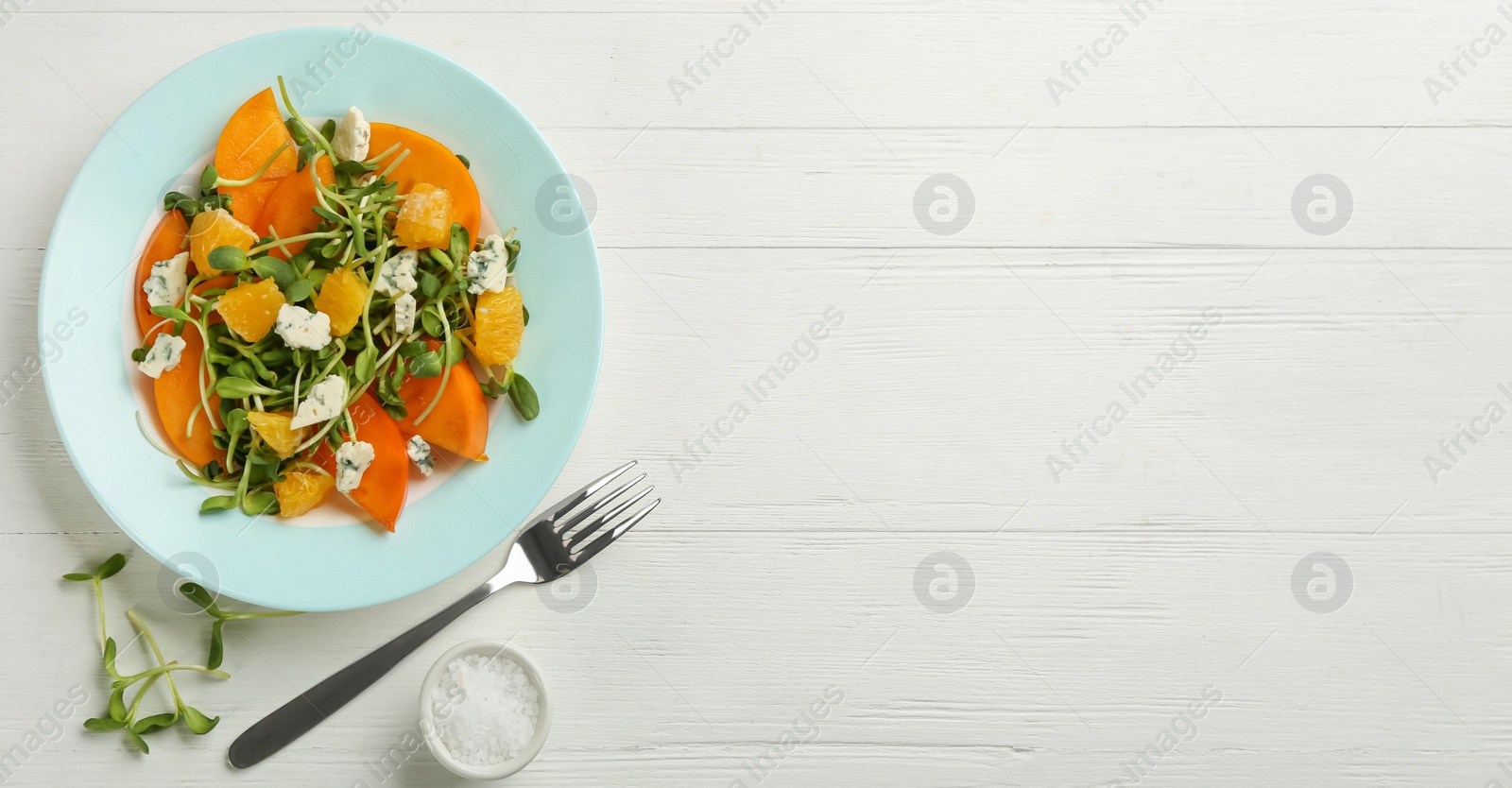 Photo of Delicious persimmon salad served on white wooden table, flat lay. Space for text