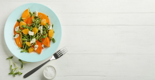 Photo of Delicious persimmon salad served on white wooden table, flat lay. Space for text