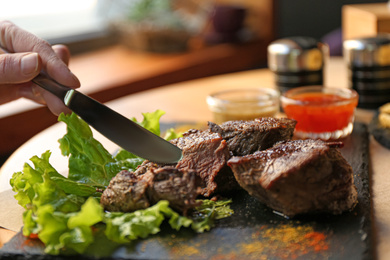 Photo of Woman eating tasty shish kebab in cafe