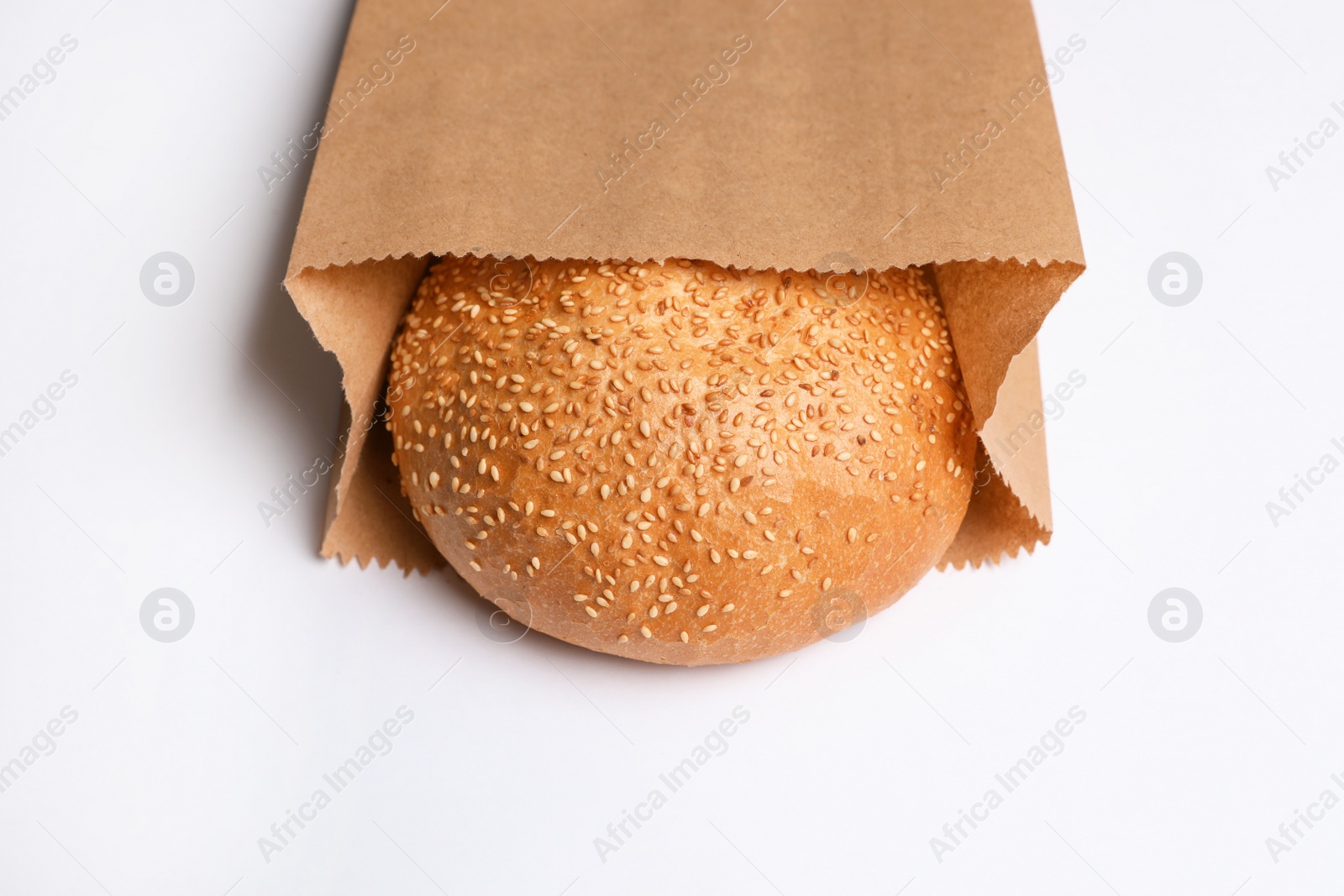 Photo of Paper bag with sesame bun on white background