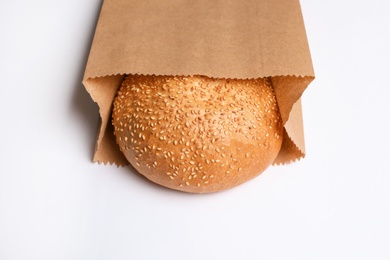 Paper bag with sesame bun on white background