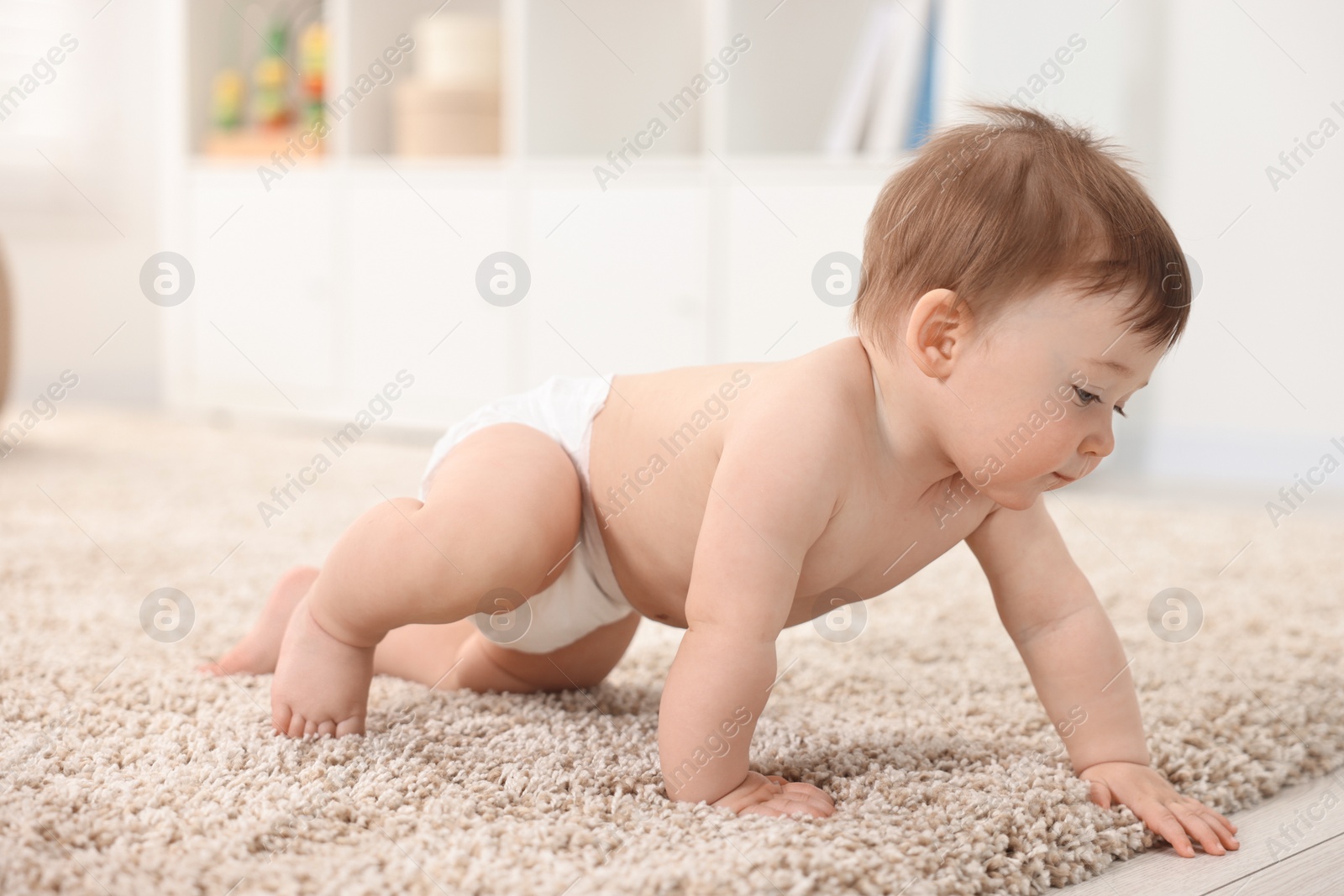 Photo of Cute baby boy crawling on carpet at home