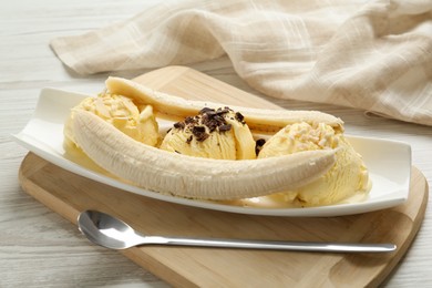 Delicious banana split ice cream with toppings on white wooden table , closeup