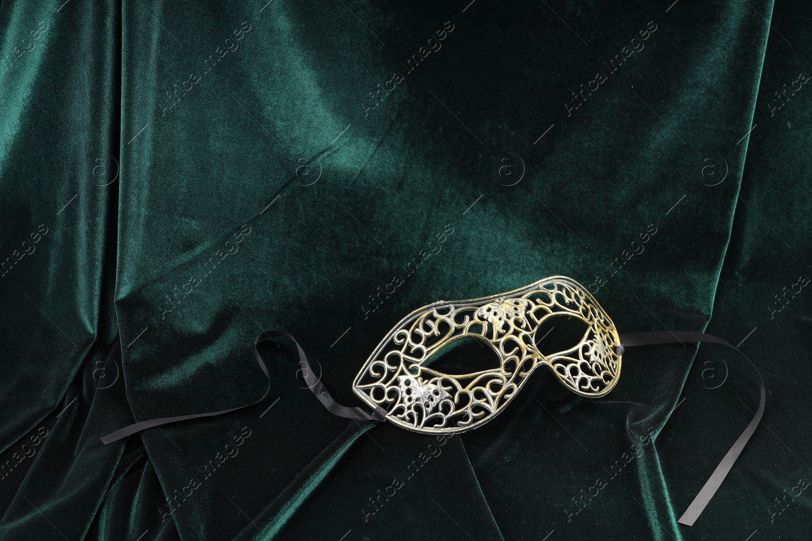 Photo of Theater arts. Venetian carnival mask on green fabric, space for text