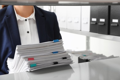 Photo of Female worker with documents in office, closeup. Space for text