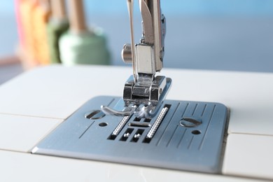 White sewing machine on light background, closeup