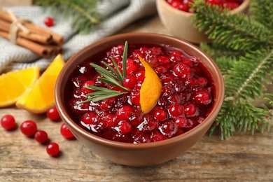 Cranberry sauce with orange peel and rosemary on wooden table