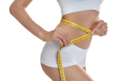 Photo of Young woman measuring waist with tape on white background, closeup