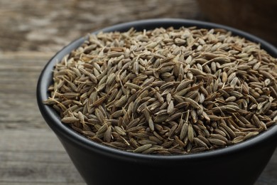 Photo of Bowl of caraway seeds on table, closeup