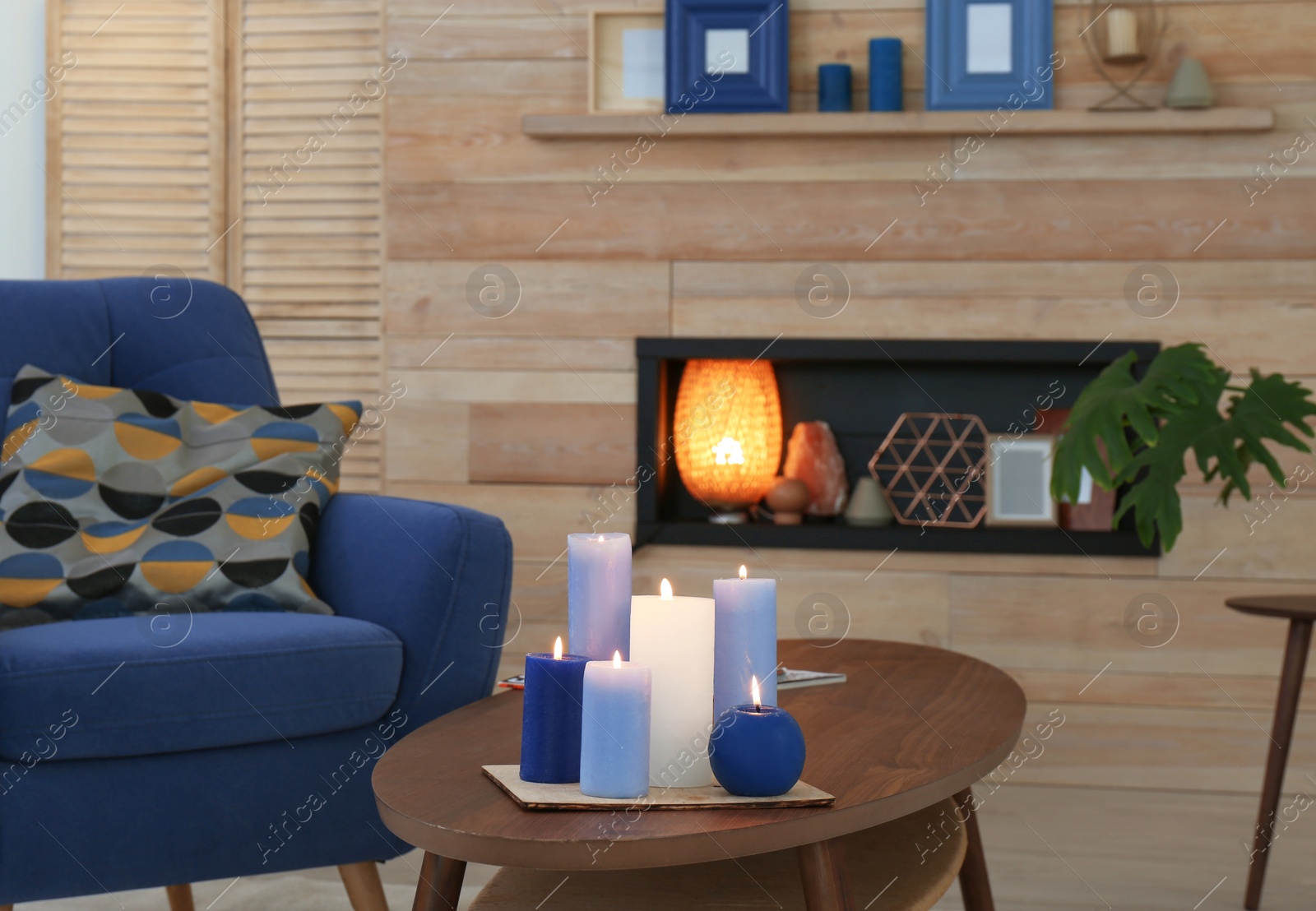 Photo of Burning candles on table in living room