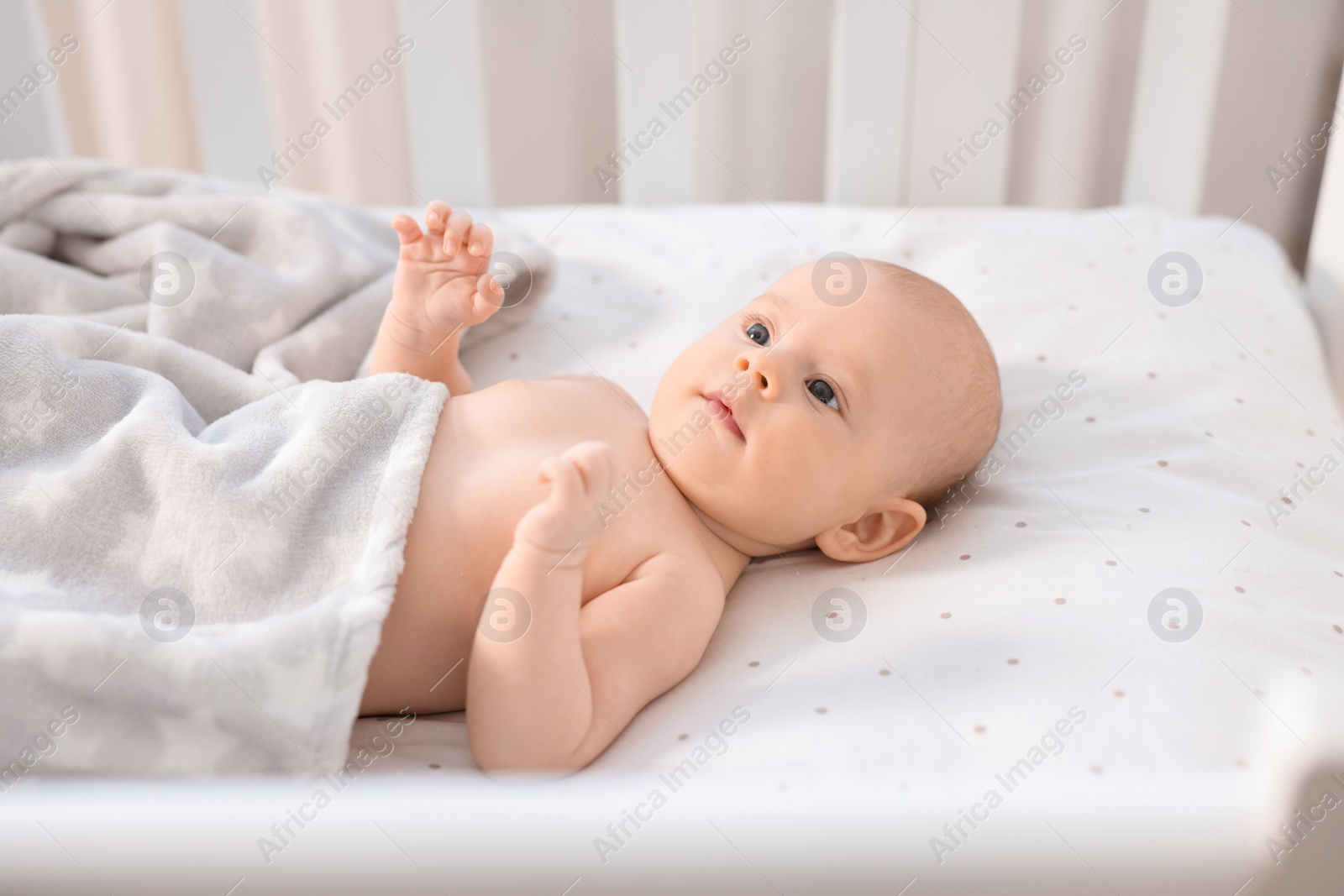 Photo of Cute little baby lying in crib at home