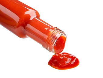 Photo of Pouring tasty ketchup from bottle isolated on white. Tomato sauce