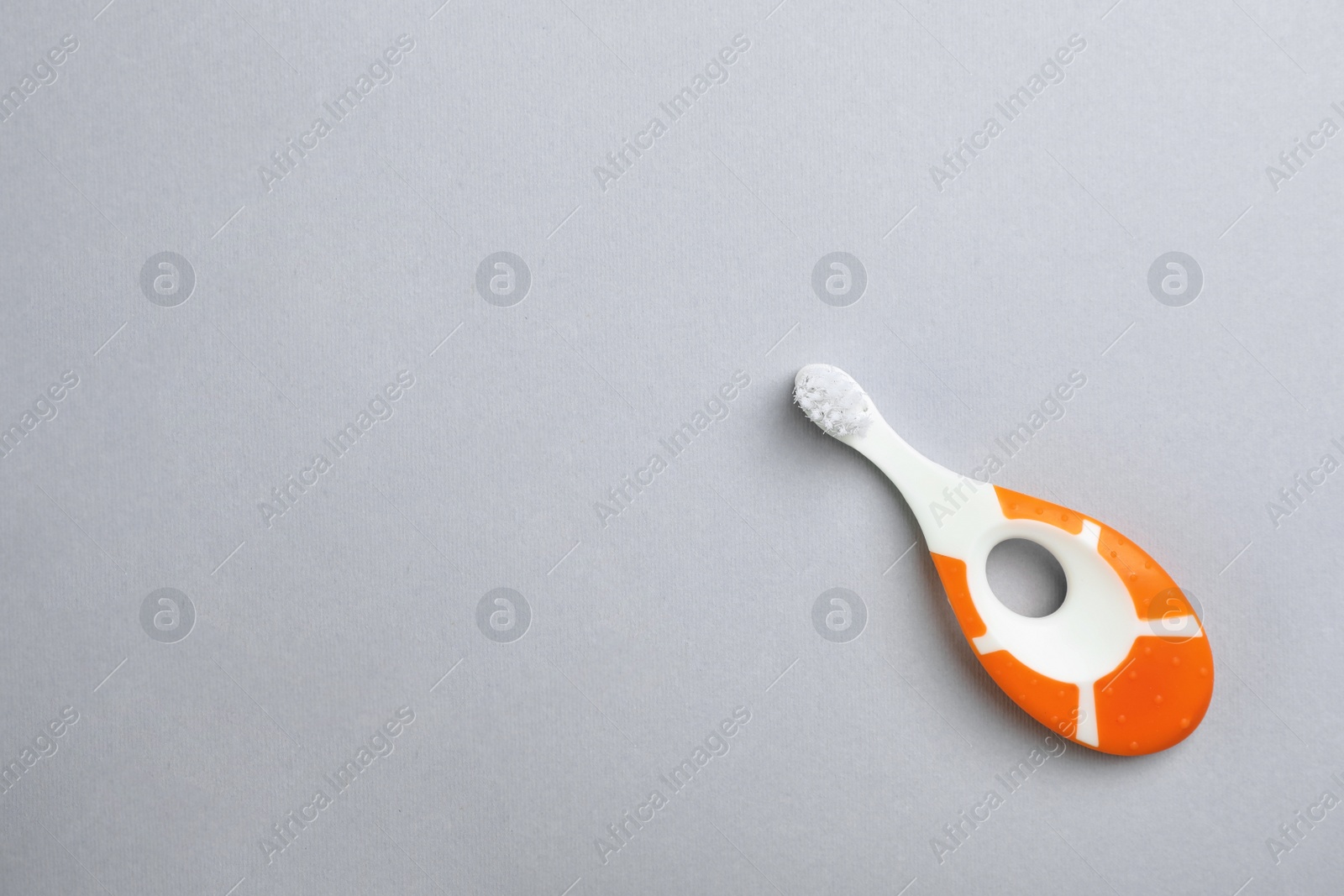 Photo of Manual toothbrush for child on gray background, top view with space for text