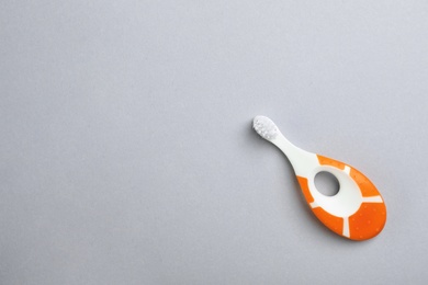 Photo of Manual toothbrush for child on gray background, top view with space for text