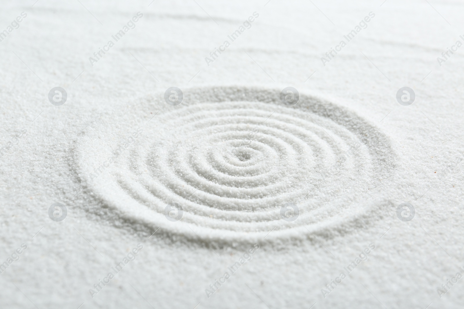 Photo of Zen rock garden. Circle pattern on white sand, closeup