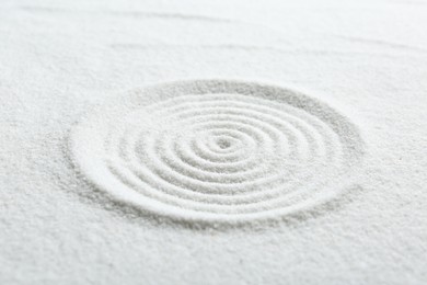 Photo of Zen rock garden. Circle pattern on white sand, closeup