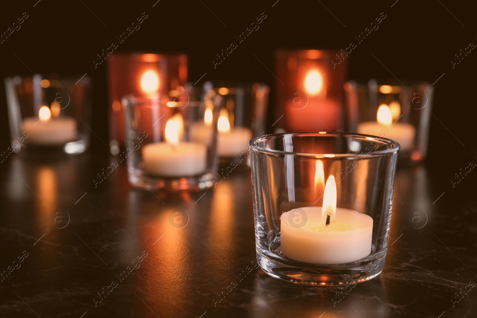 Photo of Burning candle on table in darkness, space for text. Funeral symbol