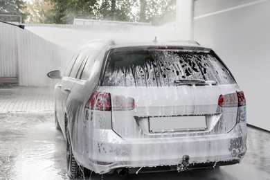 Photo of Washing auto with high pressure water jet at outdoor car wash