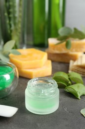 Photo of Homemade cosmetic products and fresh ingredients on black table