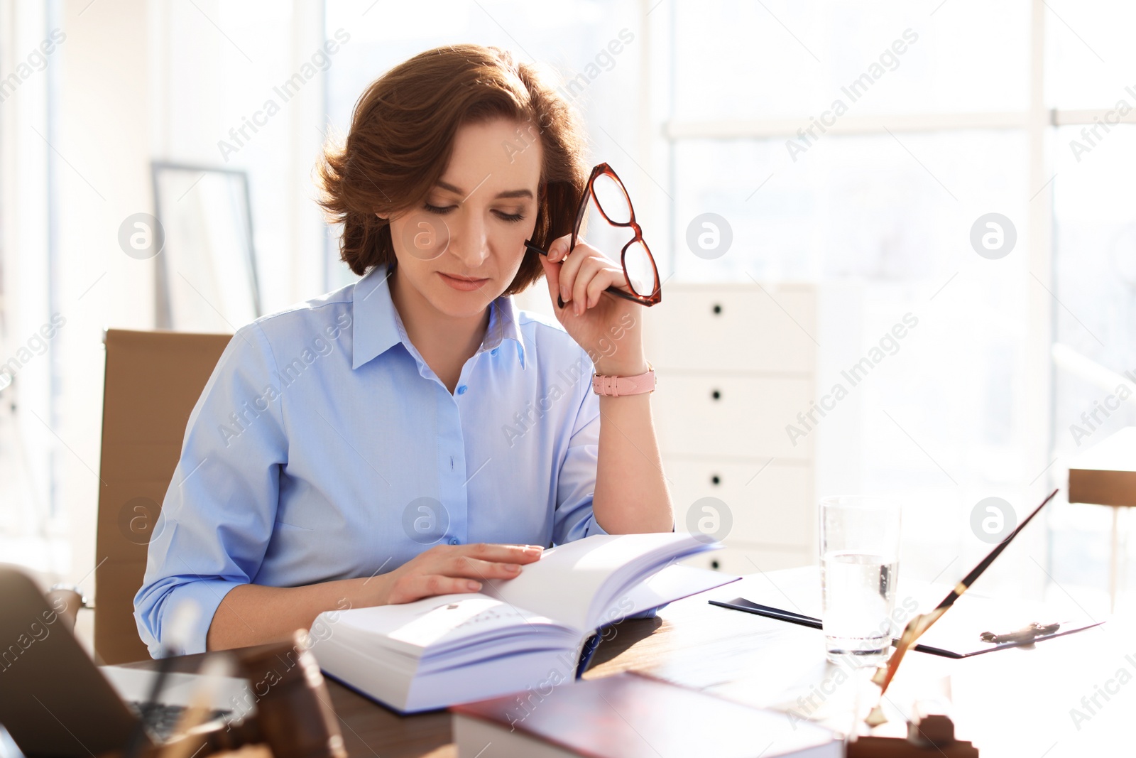 Photo of Female lawyer working at table in office