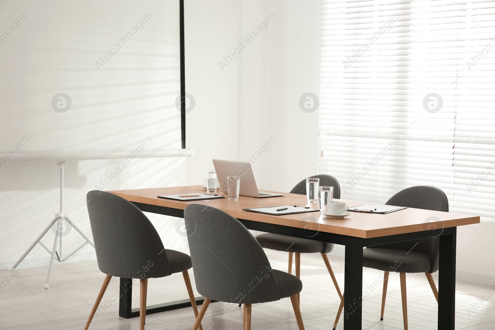 Photo of Conference room interior with wooden table and video projection screen