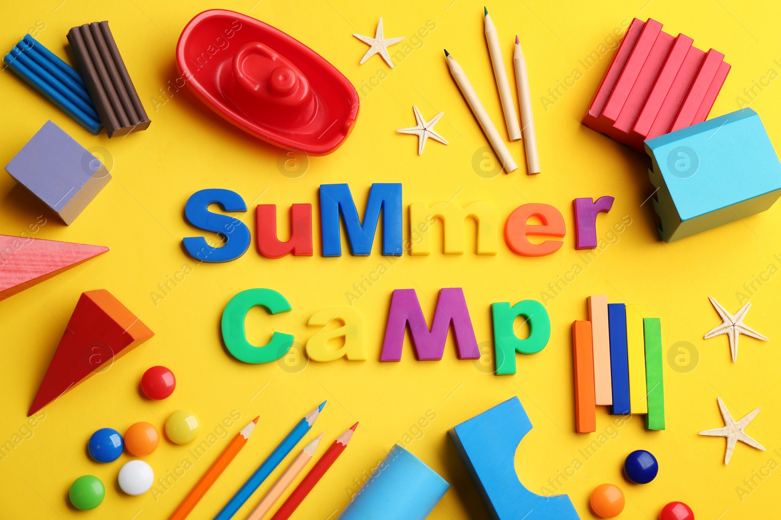 Photo of Flat lay composition with phrase SUMMER CAMP made of magnet letters on yellow background