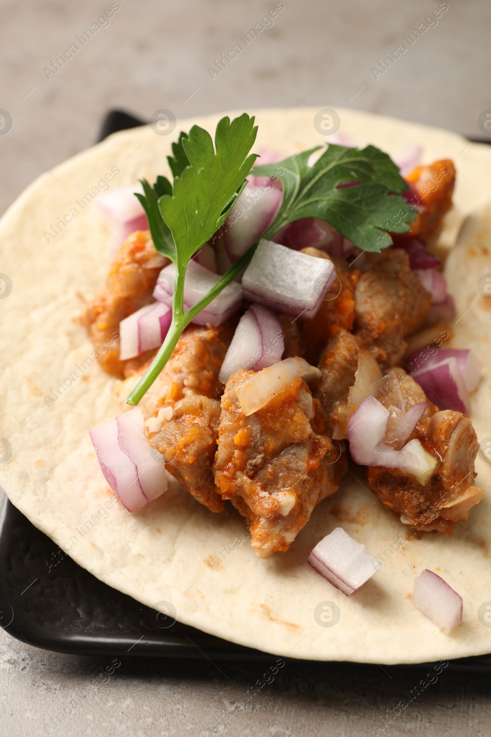 Photo of Delicious taco with vegetables and meat on grey table, closeup