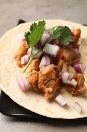 Delicious taco with vegetables and meat on grey table, closeup