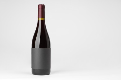 Photo of Bottle of tasty red wine on white background, space for text